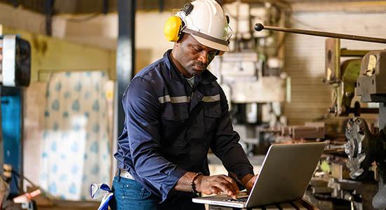 man working in hard hat on laptop