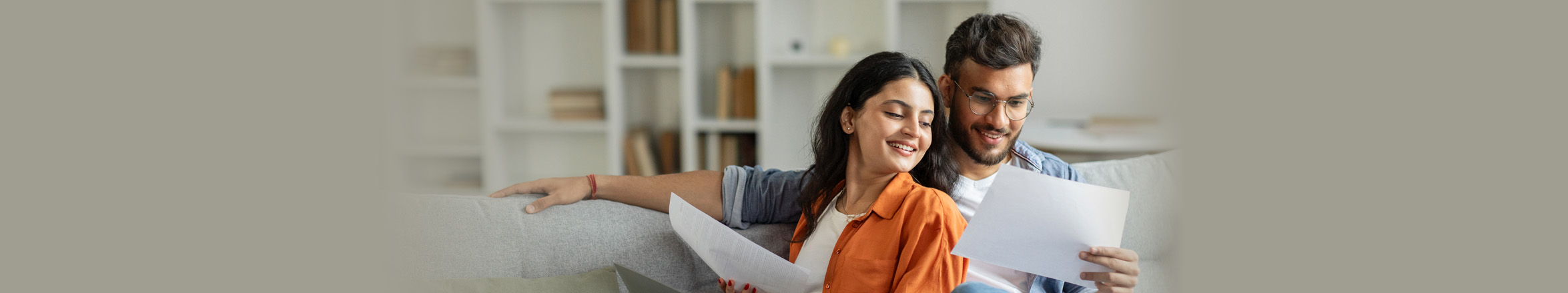 couple on couch looking at document
