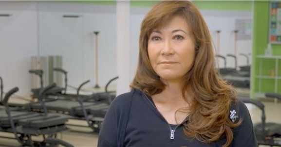 Woman in pilates studio staring into camera