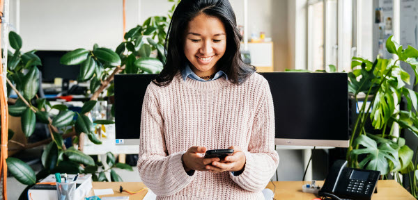 girl looking down at phone smiling